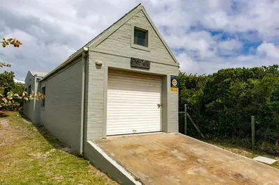 a garage with a large door on the side of a house at Bagatelle in Pringle Bay