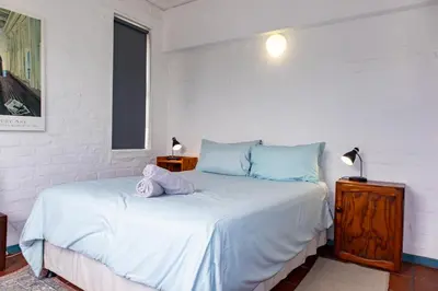 a bedroom with a bed with a stuffed animal on it at Bagatelle in Pringle Bay