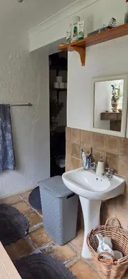 a bathroom with a white sink and a mirror at Bot River Farm Cottage in Botrivier
