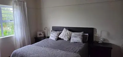 a bedroom with a bed with pillows and a window at Bot River Farm Cottage in Botrivier