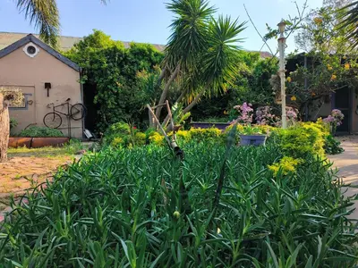 a garden with plants and flowers in front of a house at The Hermon Hotel in Hermon