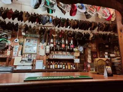a bar with a lot of hats hanging from the wall at The Hermon Hotel in Hermon