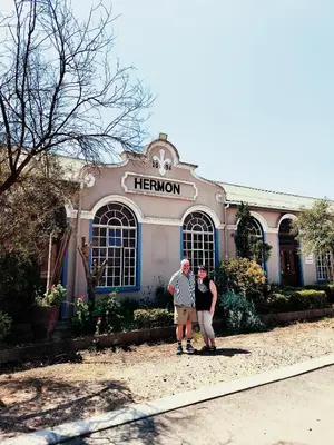 an older man and woman standing in front of a hermon building at The Hermon Hotel in Hermon