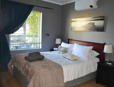 a bedroom with a bed with two pillows and a window at 2-Bedroom Private Garden Flat, Durbanville in Durbanville