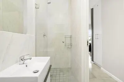 a white bathroom with a sink and a shower at The Orion 16 in Table View
