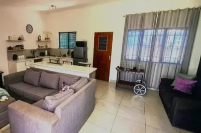 a living room with a couch and a kitchen at Bed and Biscuits in Windmeul