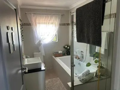 a bathroom with a tub and a sink and a shower at Chasing Sunsets sea and mountain views in Hermanus