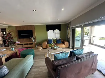 a living room with leather furniture and a christmas tree at Chasing Sunsets sea and mountain views in Hermanus