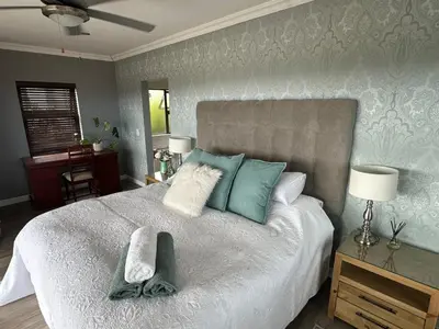 a bedroom with a large bed with towels on it at Chasing Sunsets sea and mountain views in Hermanus