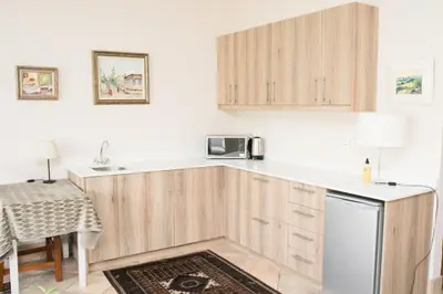a kitchen with wooden cabinets and a counter top at Villa Pascal Guest House in Durbanville