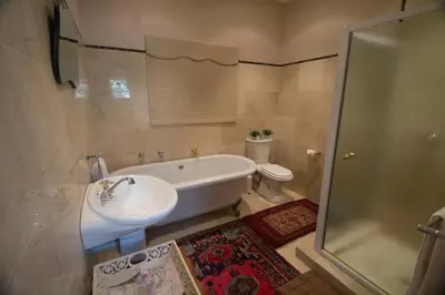 a bathroom with a tub and a sink and a toilet at Villa Pascal Guest House in Durbanville