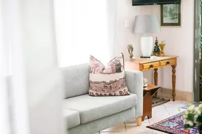 a pillow sitting on a chair in a living room at Villa Pascal Guest House in Durbanville