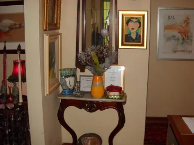 a table with a vase of flowers on it at Villa Pascal Guest House in Durbanville