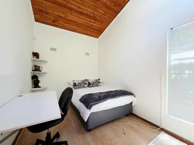 a small bedroom with a bed and a desk at 22 on Breezand in Cape Town