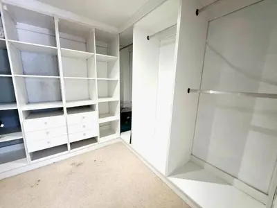 a closet with white shelves and a glass door at 22 on Breezand in Cape Town