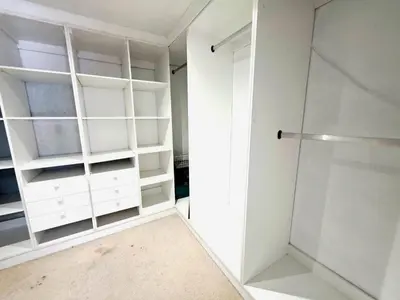 a closet with white shelves and a glass door at 22 on Breezand in Cape Town