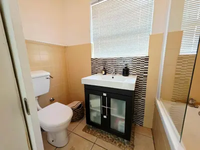 a bathroom with a white toilet and a sink at 22 on Breezand in Cape Town