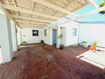 an open patio with a brick floor and a wooden ceiling at 22 on Breezand in Cape Town