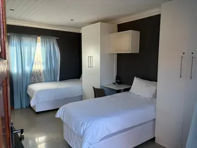 a hotel room with two beds and a window at SNE Travellers in Faure