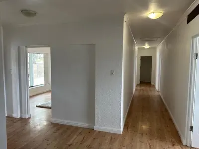 an empty living room with white walls and wood floors at Plattekloof guest house in Tygerberg Hills