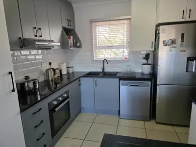 a kitchen with a refrigerator and a dishwasher at Secure 2 Bedroom Ground Floor Apartment in Joostenberg Vlakte