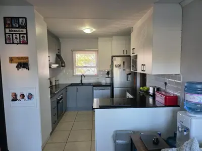 a kitchen with white cabinets and a counter top at Secure 2 Bedroom Ground Floor Apartment in Joostenberg Vlakte