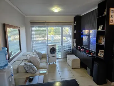 a living room with a couch and a tv at Secure 2 Bedroom Ground Floor Apartment in Joostenberg Vlakte