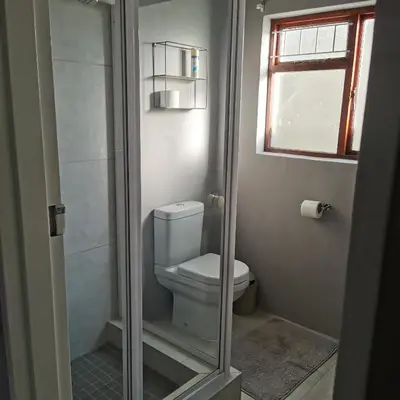 a bathroom with a toilet with a glass shower door at Sune's self catering 2 in Worcester