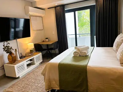 a hotel room with a bed and a television at Bachelors Unit at The Den in Stellenbosch