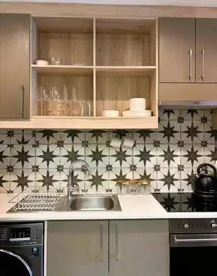 a kitchen with a sink and black and white tiles at Bachelors Unit at The Den in Stellenbosch
