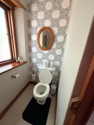a bathroom with a toilet and a mirror on a wall at Lux in Paarl