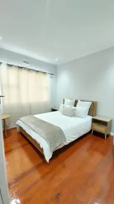 a bedroom with a large white bed and wooden floors at B3 bnb House