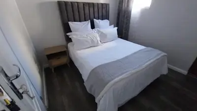 a bedroom with a bed with white sheets and pillows at B3 bnb House