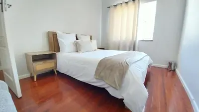 a bedroom with a white bed and a wooden floor at B3 bnb House