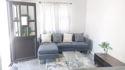 a living room with a blue couch and a window at B3 bnb House