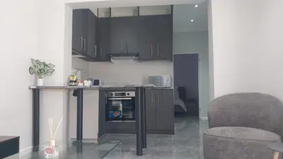 a kitchen with black cabinets and a counter top at B3 bnb House