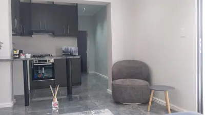 a kitchen with a chair and a table and a counter at B3 bnb House