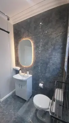 a bathroom with a toilet and a sink and a mirror at B3 bnb House