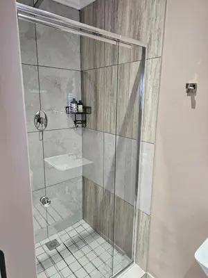 a shower with a glass door and a sink at Cape Town Glam in Welgemoed