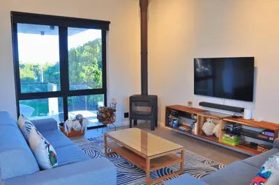 a living room with a blue couch and a fireplace at Modern 4BDR Flaming Bay in Hermanus in Hermanus