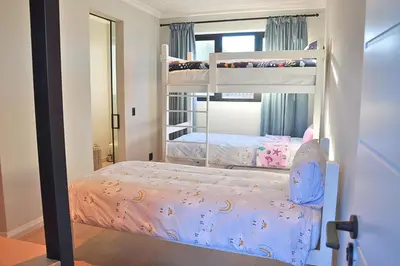 a bedroom with two bunk beds and a mirror at Modern 4BDR Flaming Bay in Hermanus in Hermanus