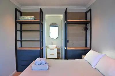 a bedroom with a bed with a sink and a mirror at Modern 4BDR Flaming Bay in Hermanus in Hermanus