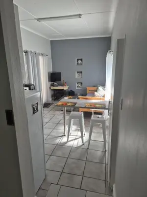 a living room with a table and two stools at Suné's Self Catering 1 in Worcester