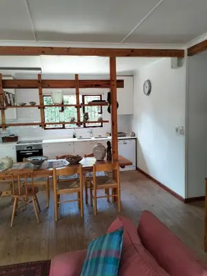 a kitchen and dining room with a table and chairs at Pet Friendly Sandbaai in Hermanus