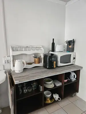 a kitchen with a microwave on a wooden shelf at Escape Root in Caledon