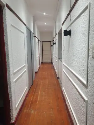 a corridor with white doors and a wooden floor at Ludinz Self Catering Guest House
