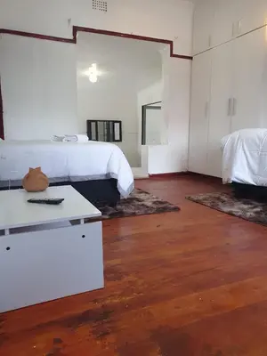 a bedroom with a bed and a table with a table at Ludinz Self Catering Guest House