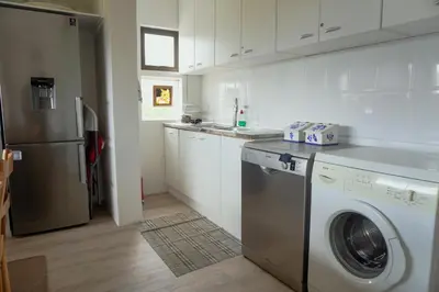 a kitchen with a washing machine and a refrigerator at Leah's View in Pringle Bay