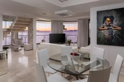 a living room with a glass table and a painting at Main Hibernian Penthouse in Strand