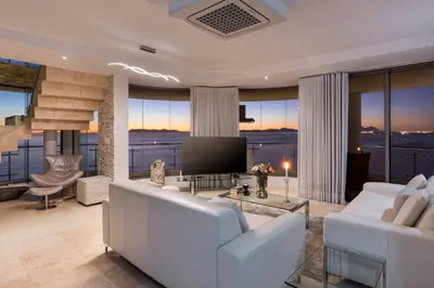 a living room with a white couch and a television at Main Hibernian Penthouse in Strand